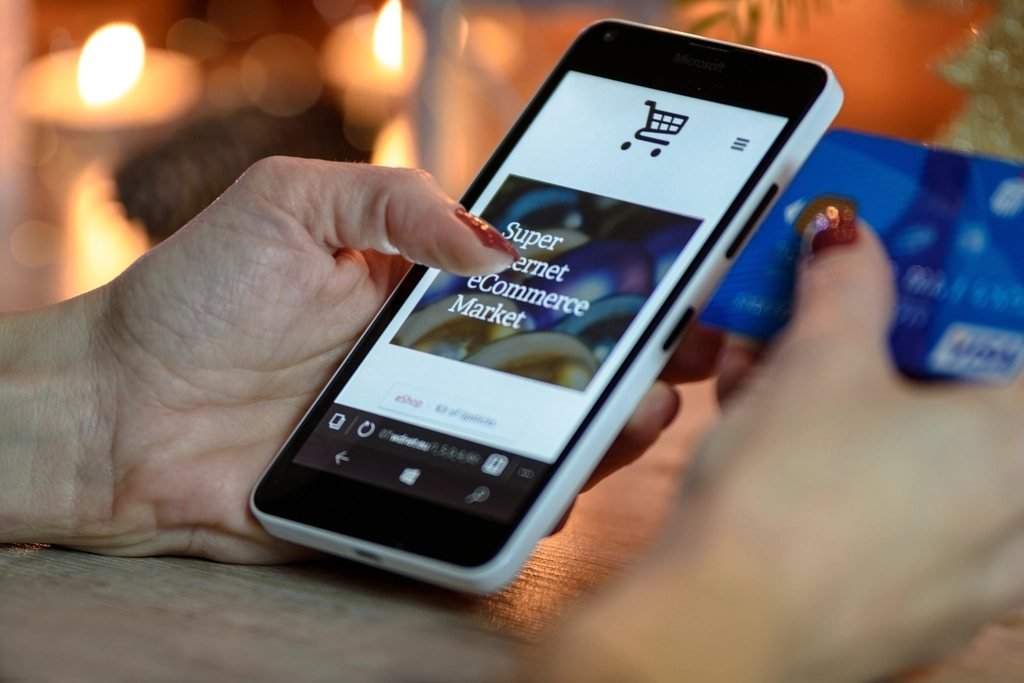 Người mua hàng trên điện thoại và thẻ tín dụng — bán hàng online cần cổng thanh toán