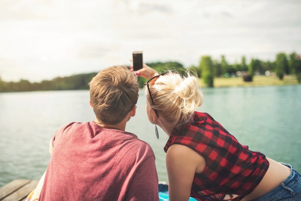 Cặp đôi chụp ảnh bằng điện thoại để đăng Instagram