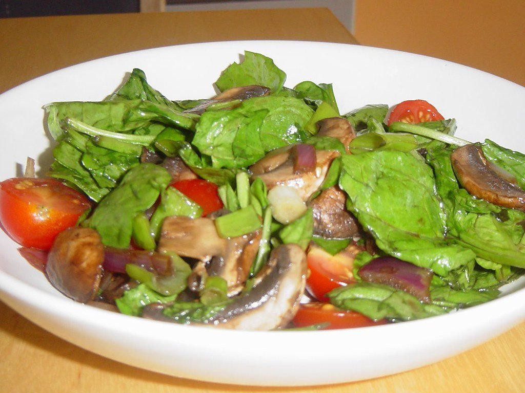 Đĩa salad rau bina, nấm và cà chua — thói quen ăn uống mà health coach giúp khách thay đổi