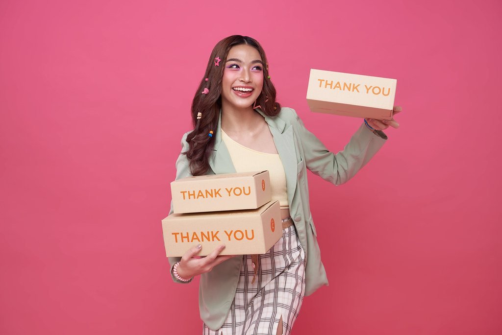 Người phụ nữ cầm các hộp giao hàng — người bán hàng online cần giữ hoá đơn chi phí để khai thuế