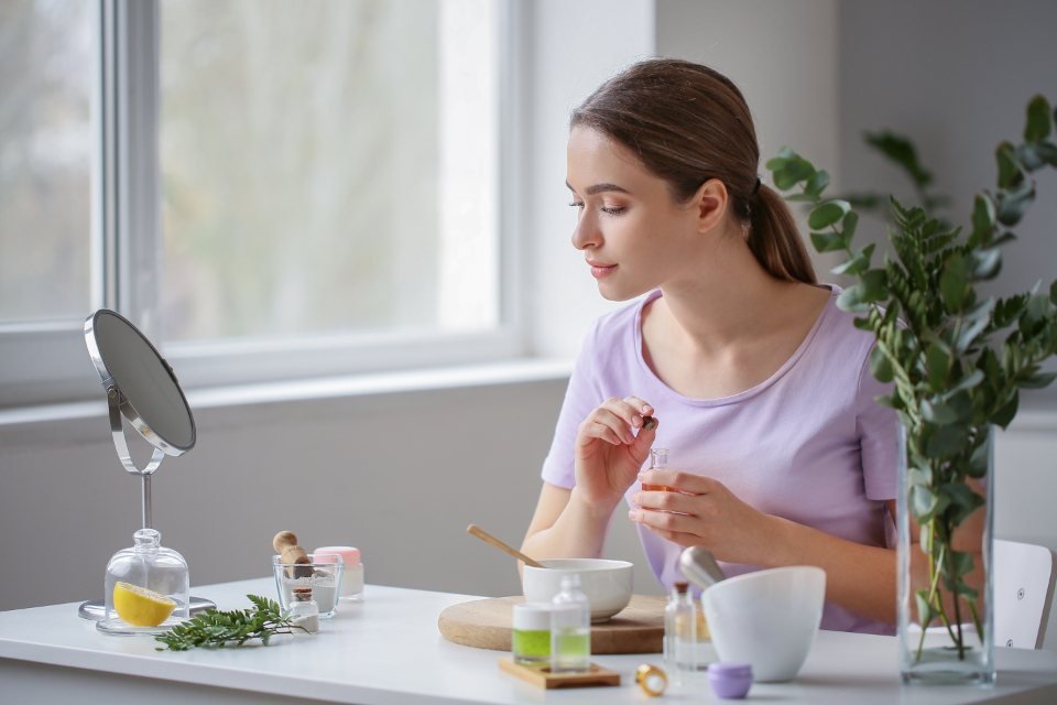Cô gái ngồi bên cửa sổ pha mỹ phẩm handmade — cảnh cận tay khi quay TikTok bán hàng